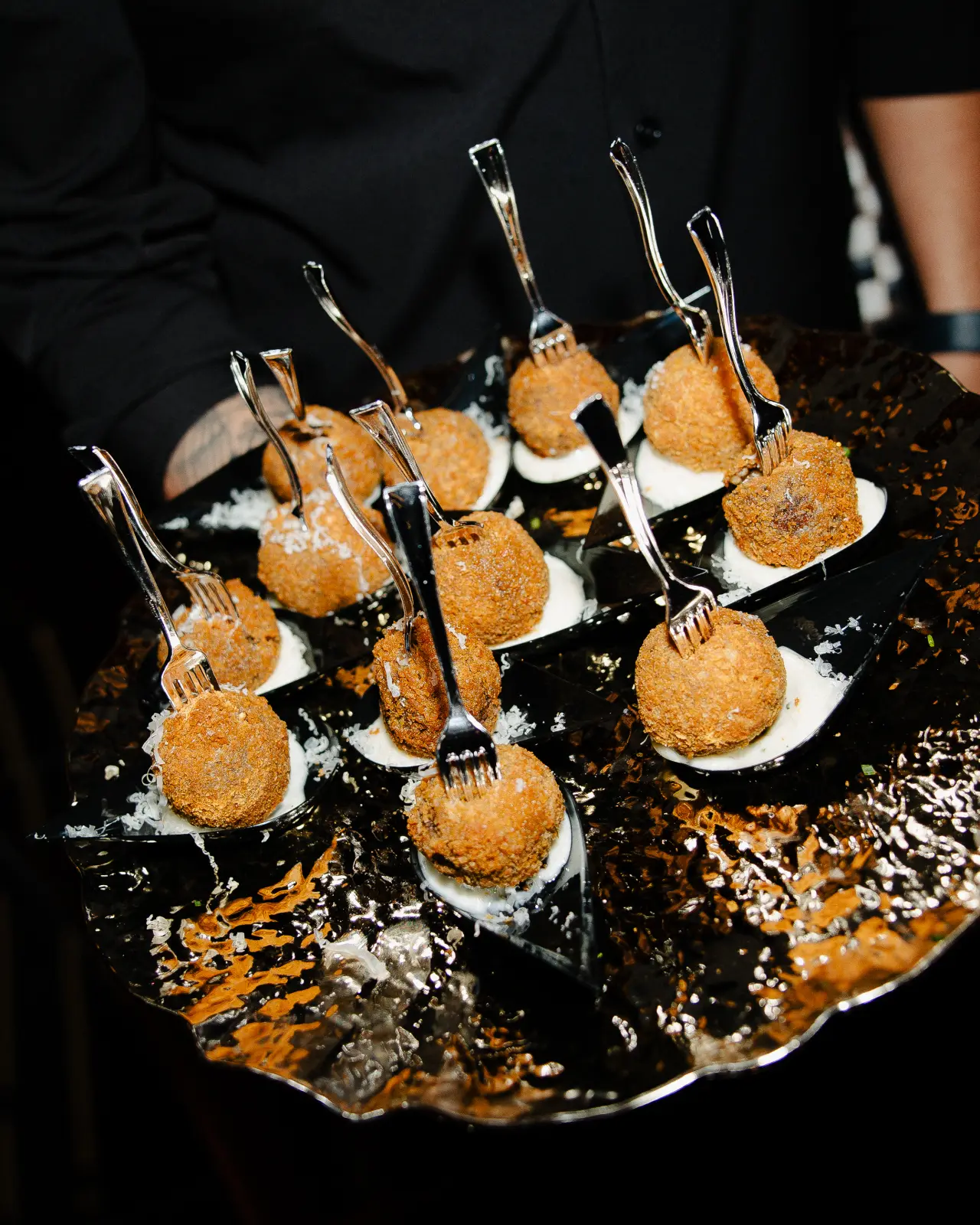 Arancini on black spoons