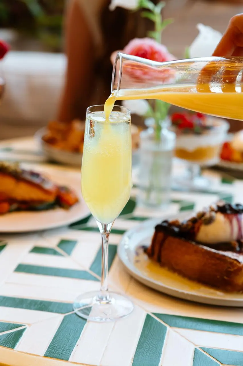 Orange juice poured into a mimosa at brunch
