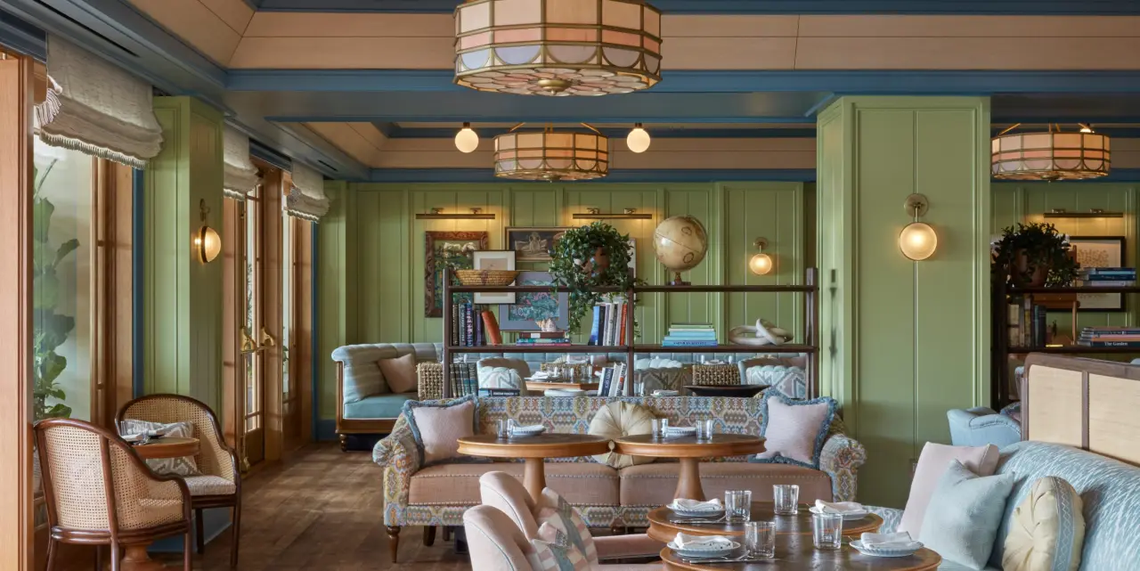 A green-panelled lounge with bookshelves and sofas