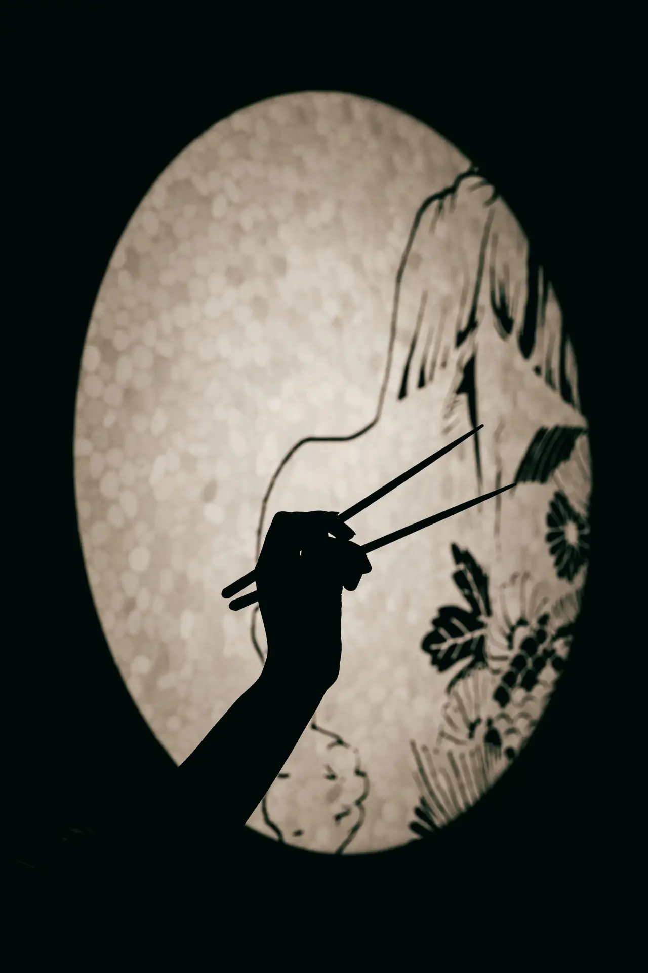 Chopsticks against a round lantern at KUZA
