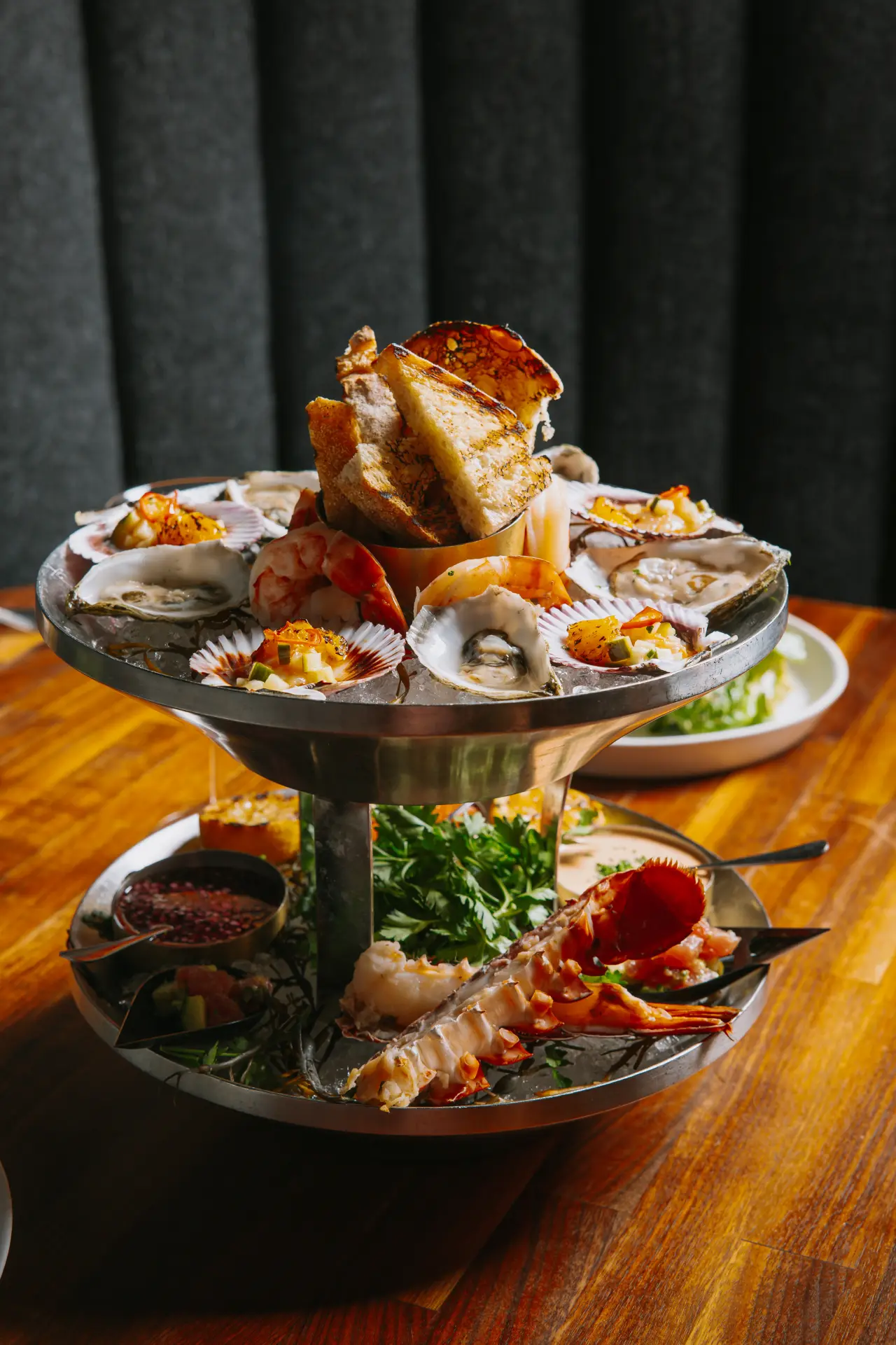A two-tier seafood tower with oysters, lobster and shrimp